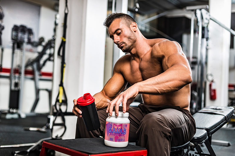 Man in gym with supplement container